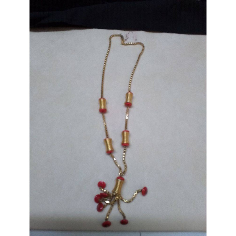 COLLIER AVEC DES PERLES CYLINDRIQUES DORÉES ET DES PERLES RONDES ROUGES.